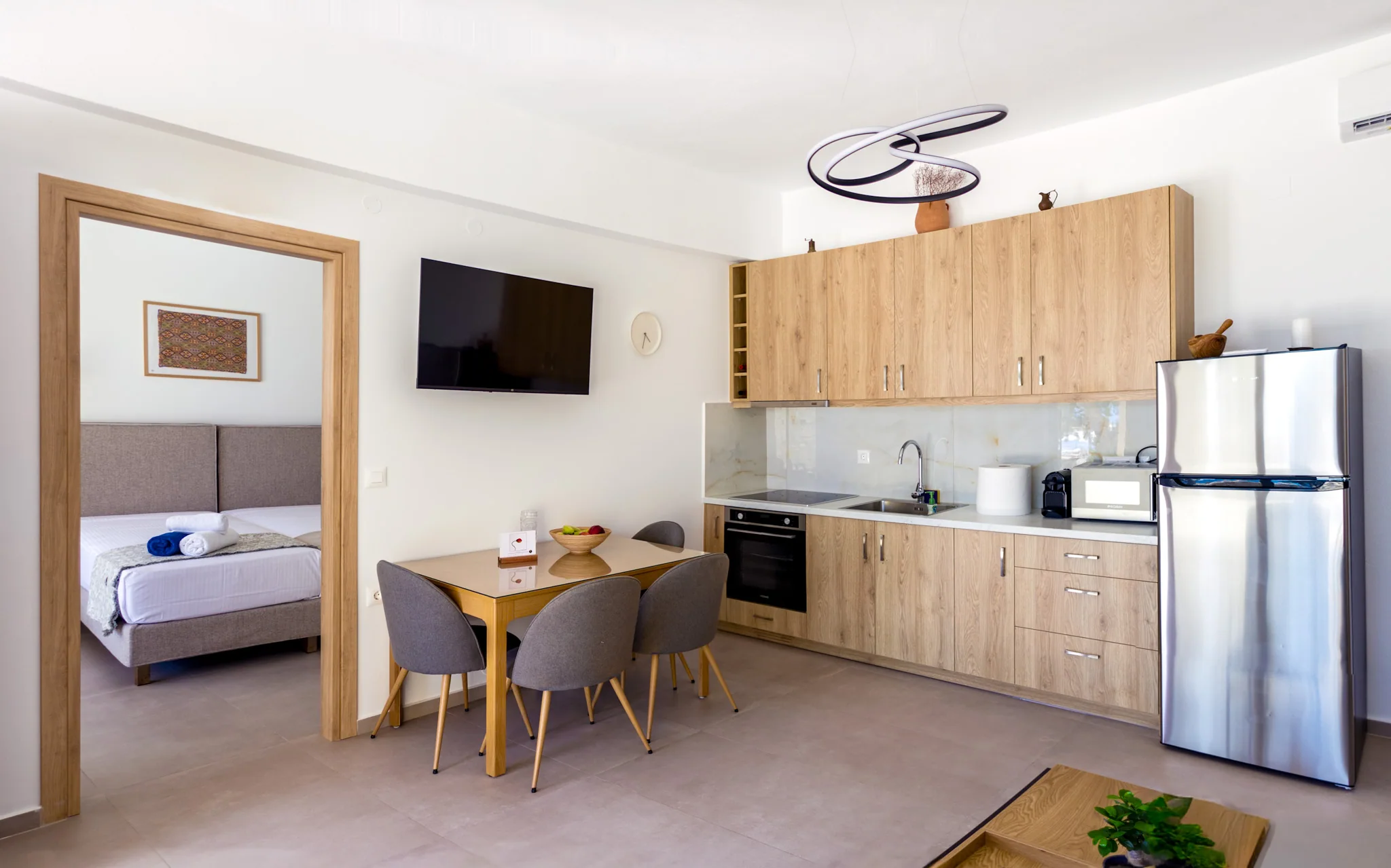 The apartment dining area and full oak kitchen, with a bedroom visible through the open doorway