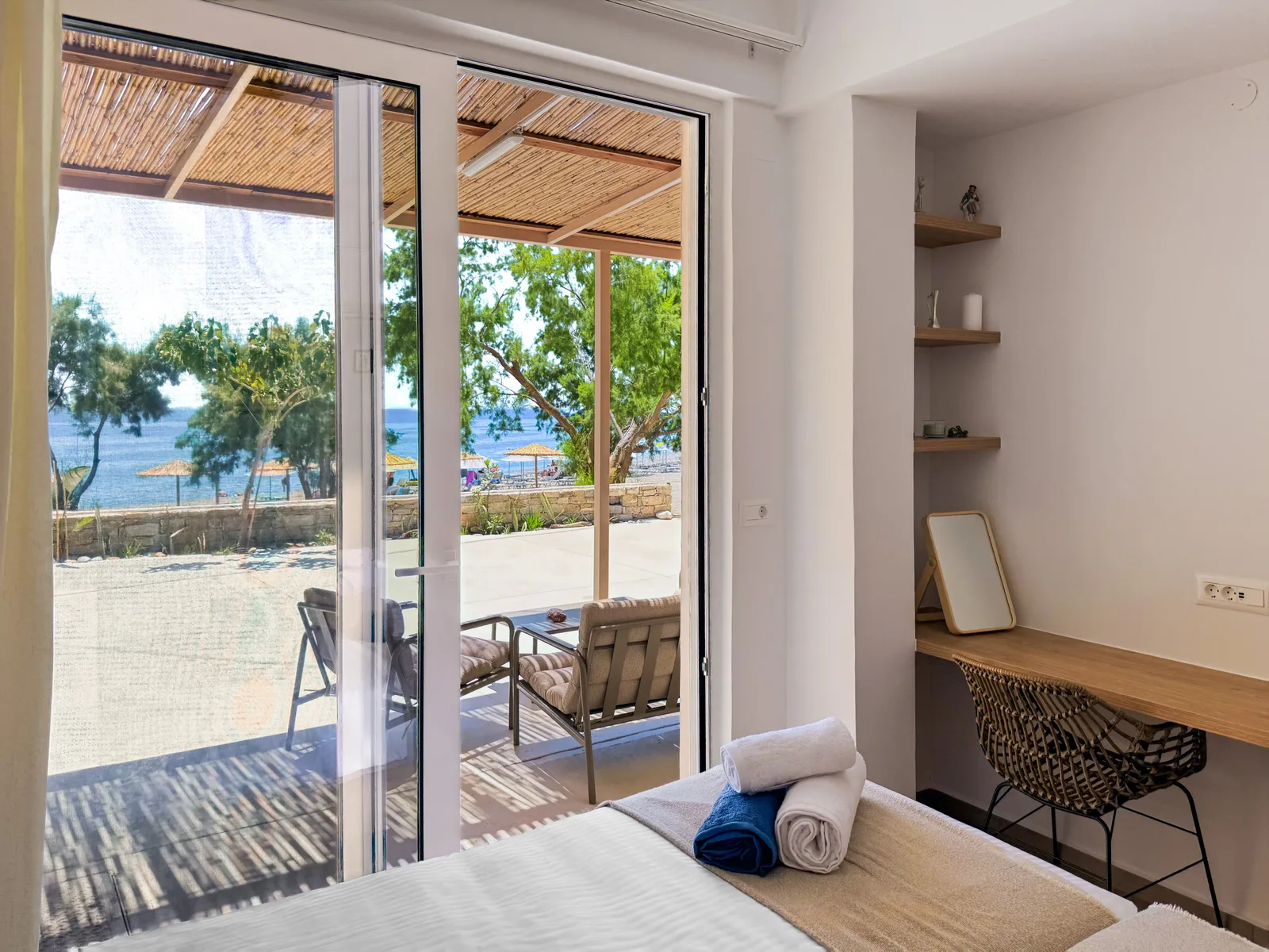 View from the apartment bed through the open doors to the terrace and sea