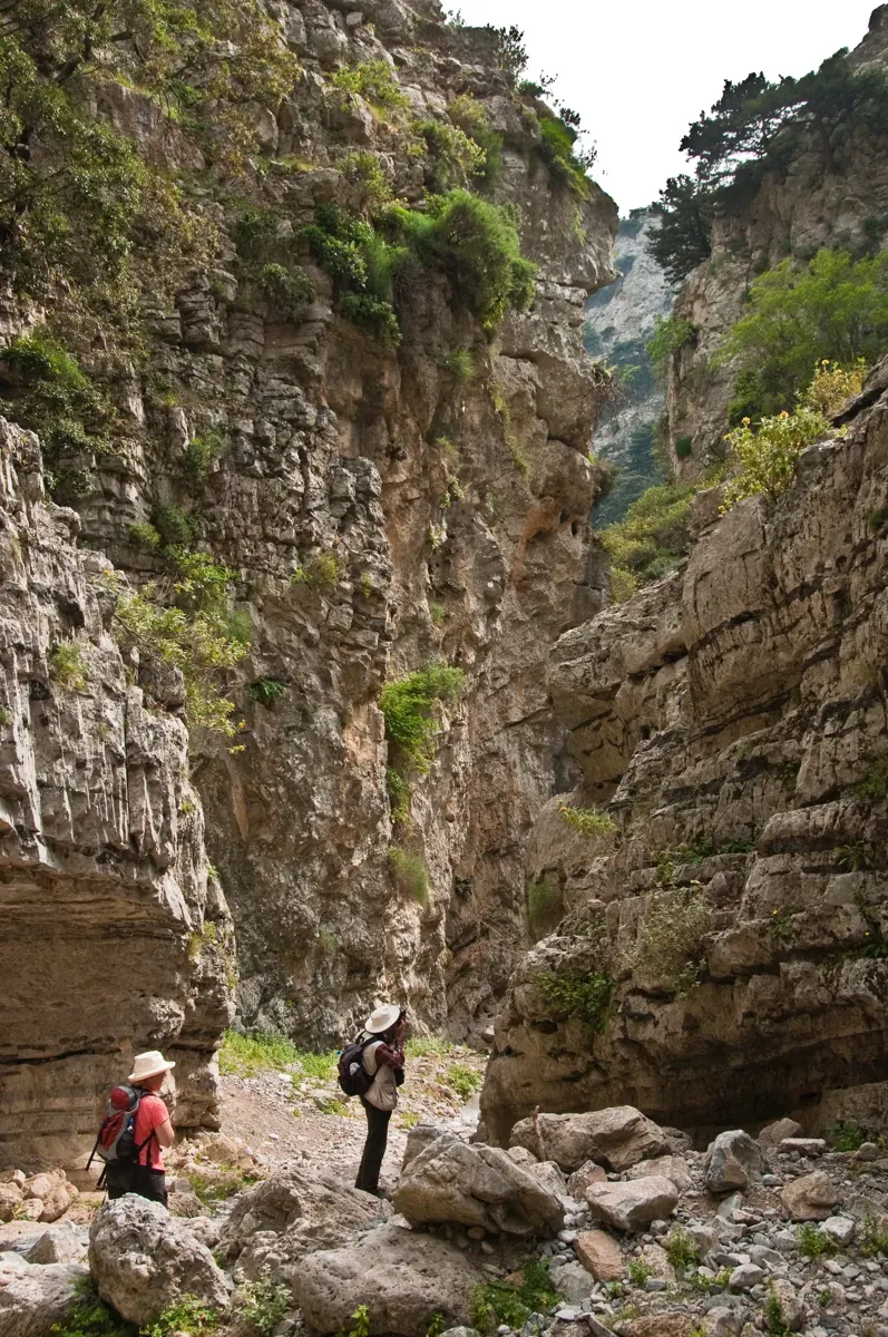 Two walkers among the high rock walls of Imbros Gorge